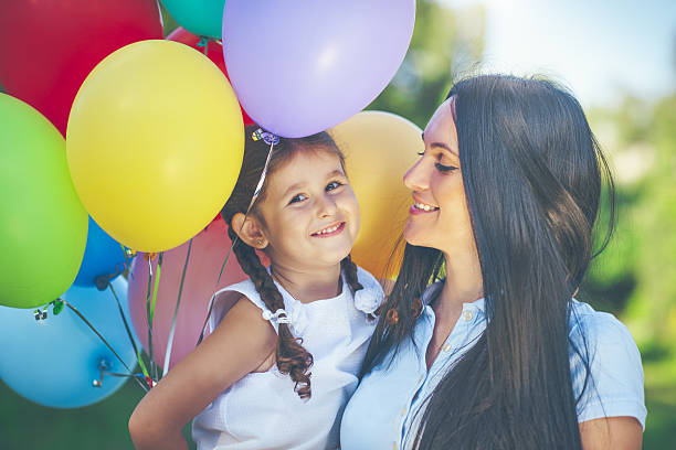 istock Mother and daughter with balloons 638931454