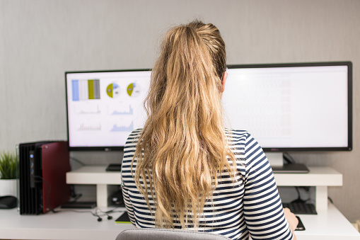 Rear view image of a young businesswoman bringing her expertise to design using computer at the office