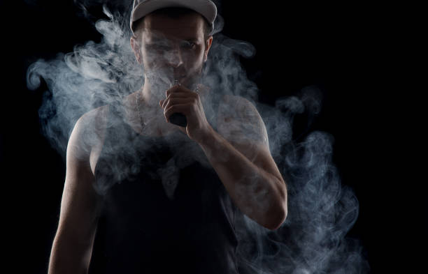 istock vaping man holding a mod. A cloud of vapor 638939102