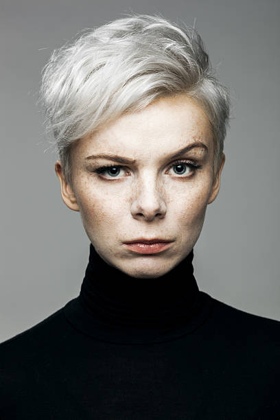 Woman With Raised Eyebrow Portrait of young confident woman looking at camera with raised eyebrow. gray hair young woman stock pictures, royalty-free photos & images