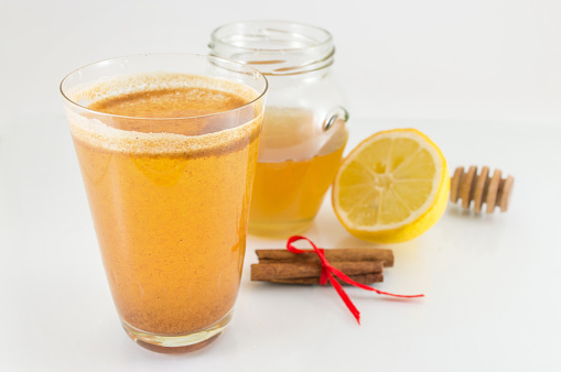 honey lemon and cinnamon drink on white background