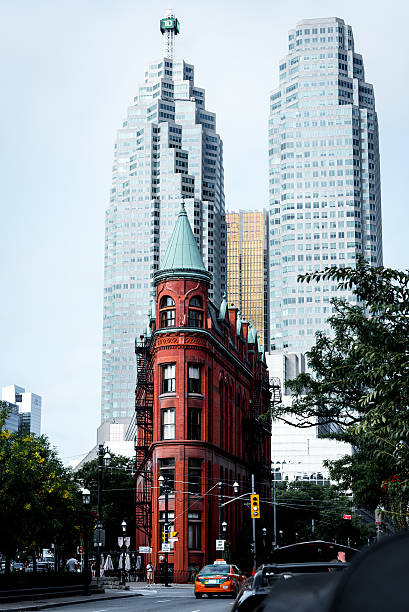 Gooderham Building and Skyscrapers in Toronto in Autumn Toronto, Canada - September 5, 2015: Front view of the Gooderham Building (the Flatiron Building) in downtown Toronto, a red-brick historic landmark of the city completed in 1892, with some modern buildings and skyscrapers in the background. flatiron building toronto stock pictures, royalty-free photos & images