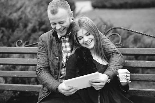 Couple walking through the city, sitting on the bench, photographed and drinking coffee