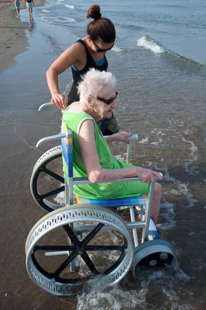 female caregiver and senior woman on a wheelchair - fotografia de stock