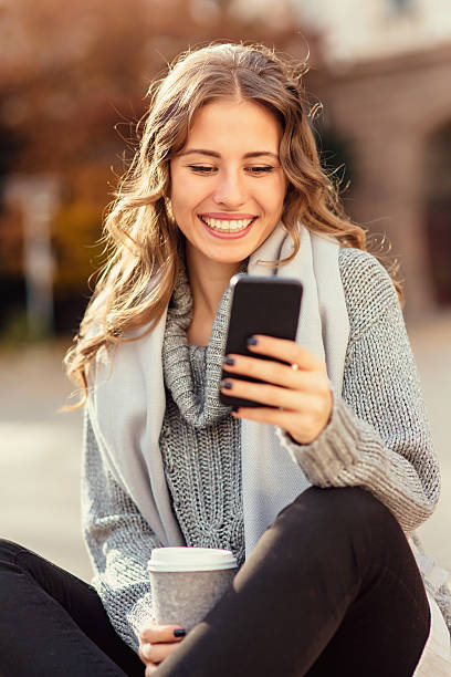 istock Young woman texting outdoors 638952036