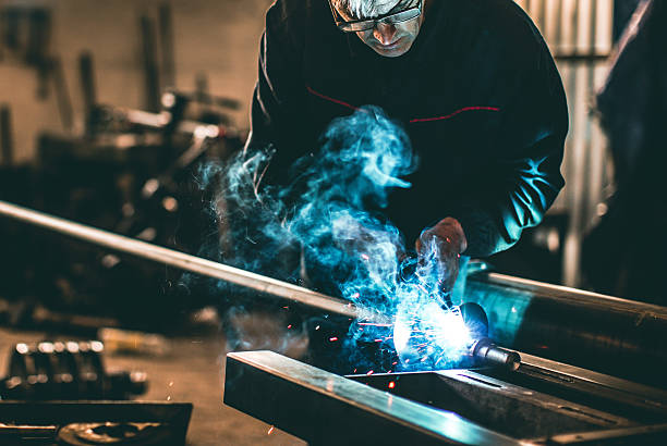 istock Welder welding metal in workshop with sparks 638952610