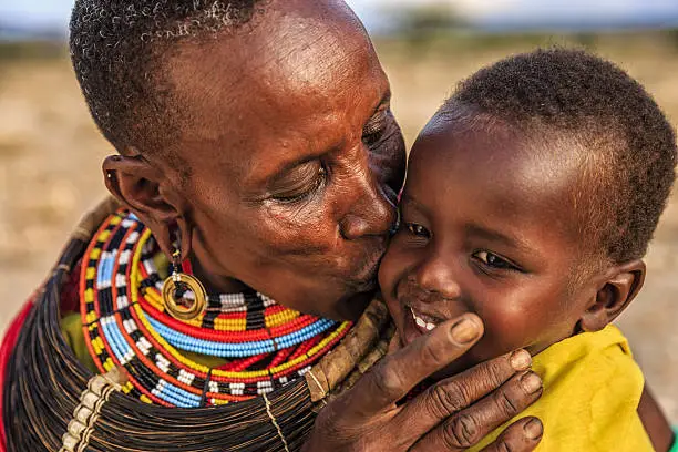 African mother from Samburu tribe kissing her baby , Kenya, Africa. Samburu tribe is one of the biggest tribes of north-central Kenya, and they are related to the Maasai.