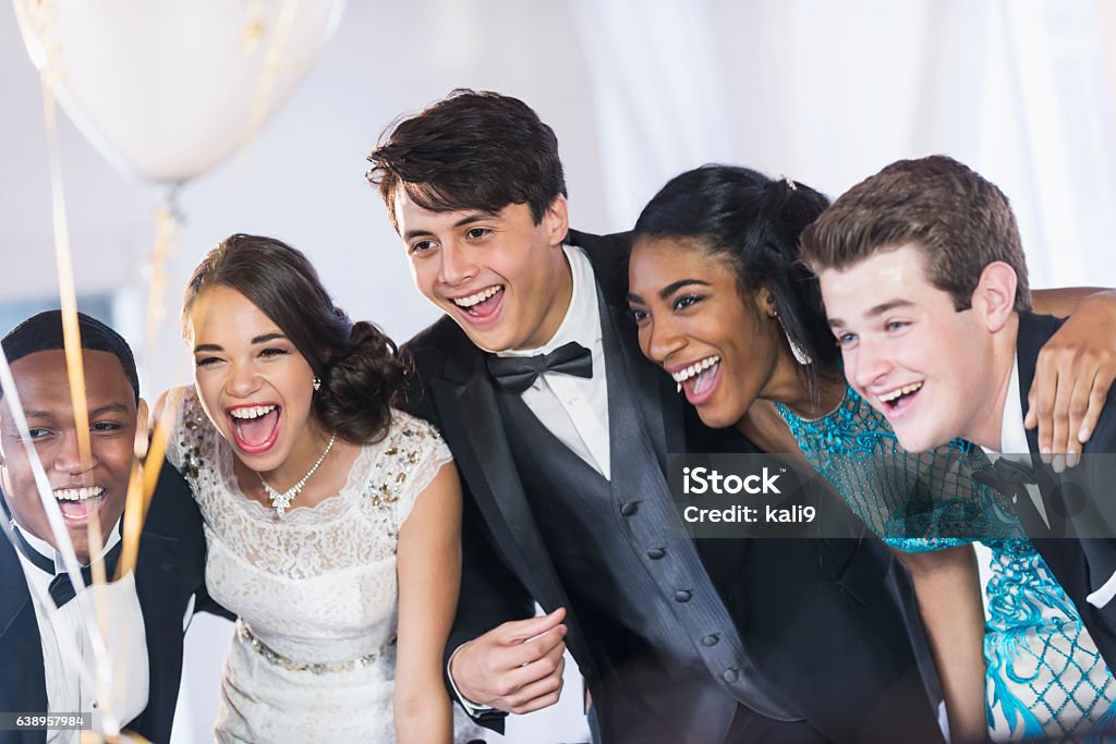 Group of teenagers at party wearing gowns and tuxedos A group of five multi-ethnic teenagers and  young adults dressed in formalwear - dresses and tuxedos. They are at a special event, perhaps a prom. Friendship Stock Photo