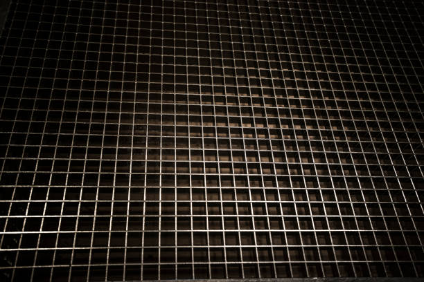 A metal grid sheet with dozens of square cutouts.