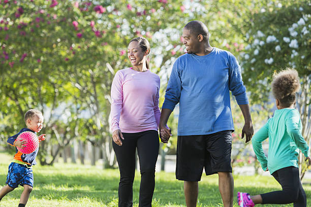 istock Black parents walking in park, children running, playing 638959914
