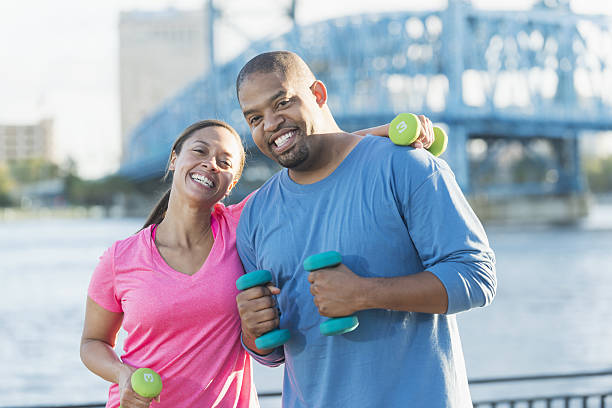 istock Black couple exercising together with handweights 638959966