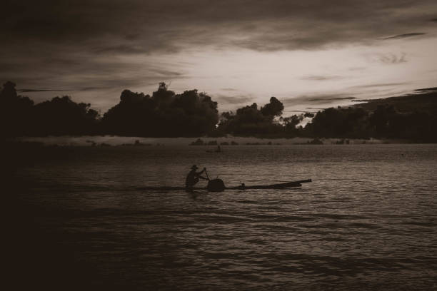 This photo shows a Fisherman with his boat on a sea for his job. This is a photo take at golden hour