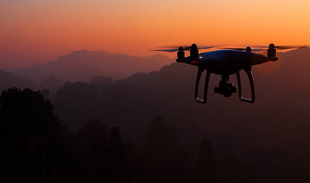 Drone quadcopter Dji Phantom 4 Zhangjiajie. China - December 16, 2016: DJI Phantom 4 drone in Zhangjiajie National Forest Park. Sunset time fly. DJI was founded in 2006, it produces unmanned, remote controlled aerial vehicles for many fields of application zhangjiajie photos stock pictures, royalty-free photos & images