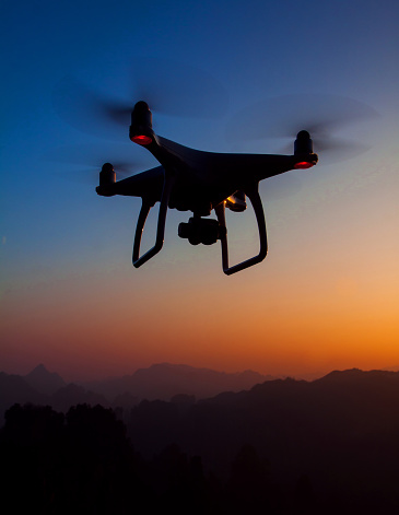 Zhangjiajie. China - December 16, 2016: DJI Phantom 4 drone in Zhangjiajie National Forest Park. Sunset time fly. DJI was founded in 2006, it produces unmanned, remote controlled aerial vehicles for many fields of application