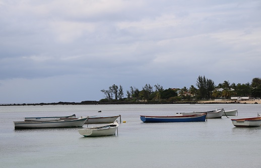 Albion, Mauritius - December 9, 2016: Boats at the beach in the western part of Mauritius during a cloudy day.