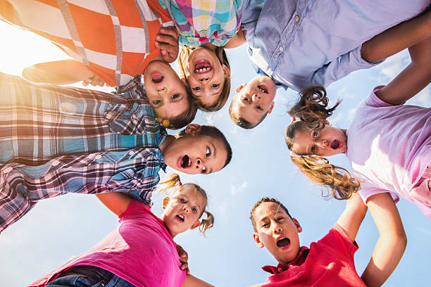istock Below view of embraced children looking at the camera. 638988754