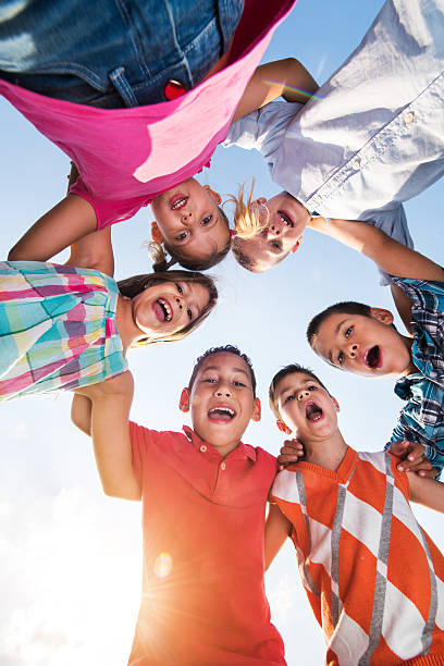 istock Group of small embraced kids shouting against the sky. 638990156
