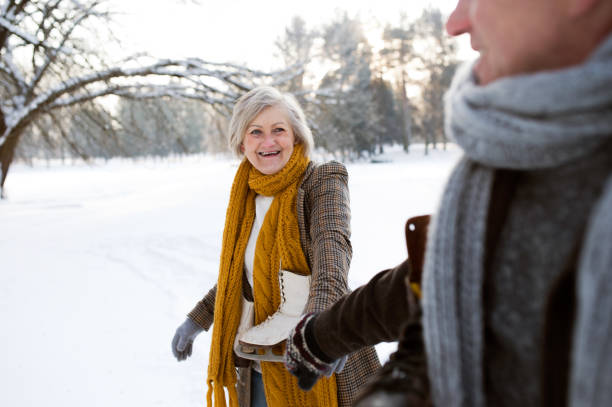 istock Senior couple in sunny winter nature going ice skating. 638992864