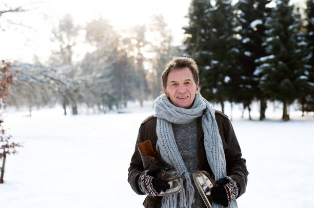 istock Senior man in sunny winter nature going ice skating. 638992902