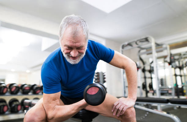 istock Senior man in gym working out with weights. 638995474