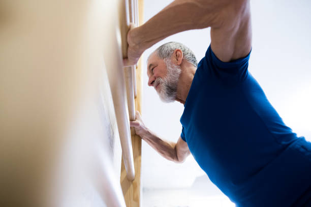 istock Senior man in gym exercising on wall bars. 638995854