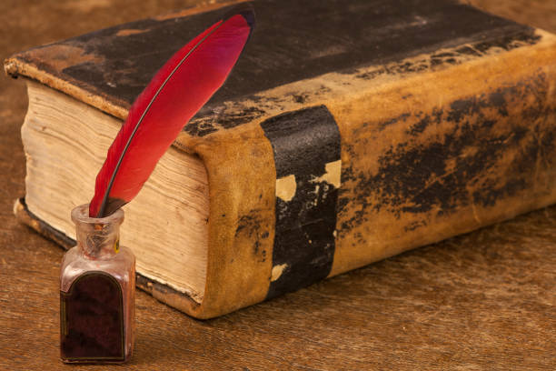 istock Old brown book, red feather and old inkwell 638995942