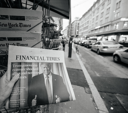 Paris, France - November 10, 2016: Man buying Financial Times newspaper with shocking headline title at press kiosk about the US President Elections - Donald Trump is the 45th President of United States of America