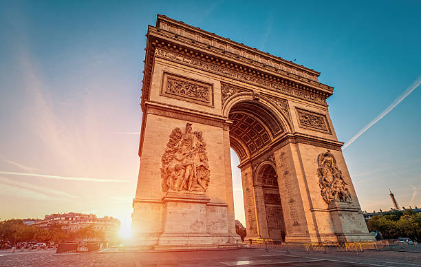 Arc de Triomphe at dawn - Paris Rush hour at the Arc de Triomphe in Paris arc de triomphe paris stock pictures, royalty-free photos & images