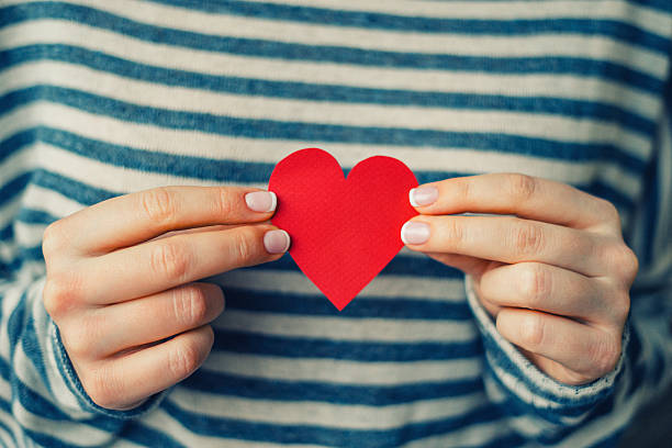 woman holding red paper heart - heart shape giving human hand gift imagens e fotografias de stock