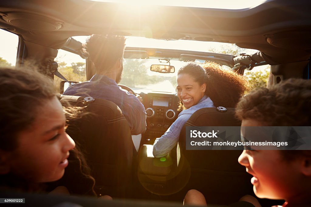 Happy family on a road trip in their car, rear passenger Happy family on a road trip in their car, rear passenger POV Family Stock Photo