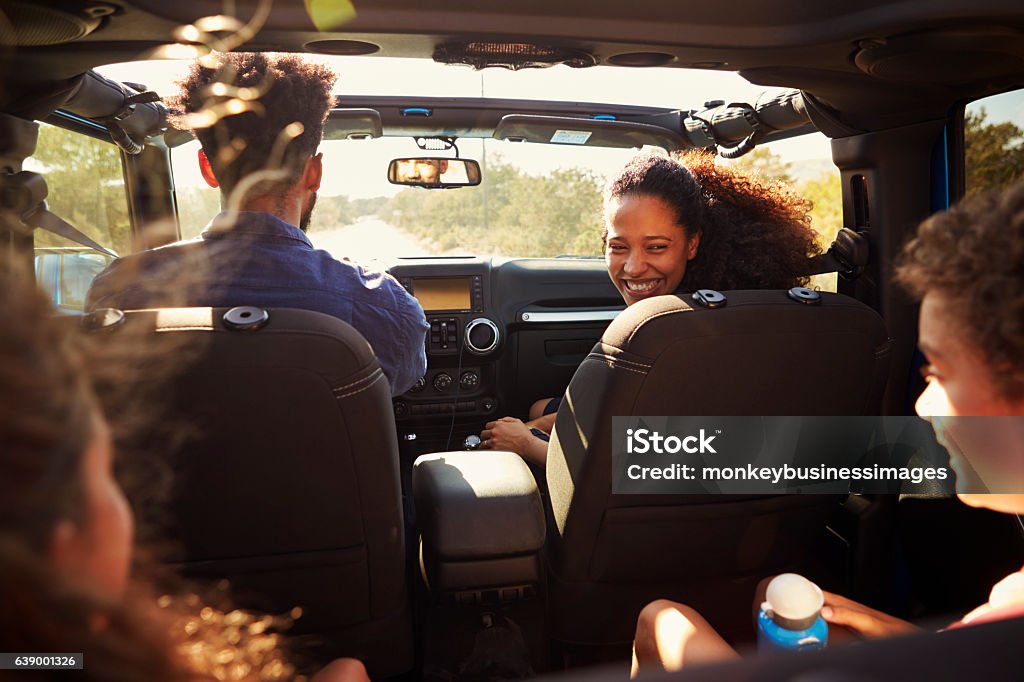 Excited family on a road trip in car, rear passenger Excited family on a road trip in car, rear passenger POV Family Stock Photo