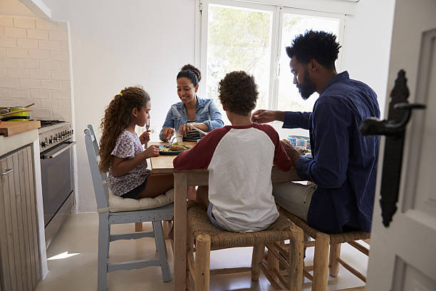istock Family eating at kitchen table, back view, seen from doorway 639001350