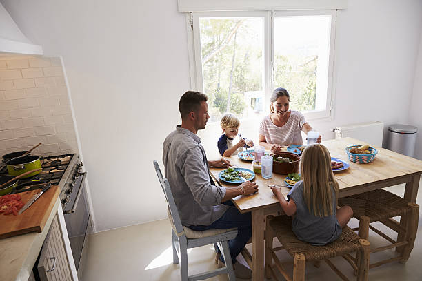 istock Family sitting down to eat lunch at kitchen table 639001400