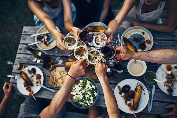 la comida y el vino unen a las personas - sentarse a comer fotos fotografías e imágenes de stock