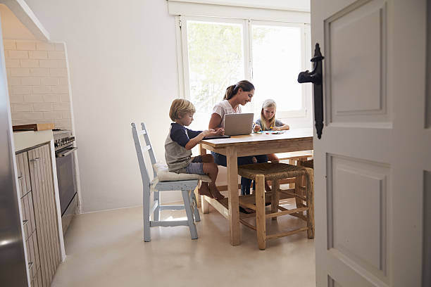 istock Mum and two kids working at kitchen table, seen from 639001776