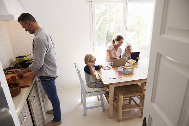 istock Dad cooking and mum with kids at the kitchen table 639001780