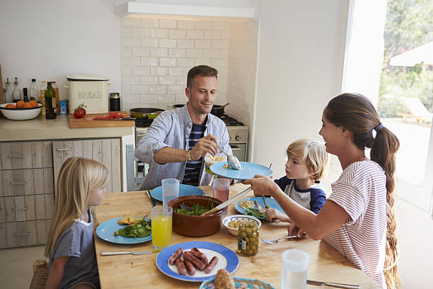 istock Family sitting around kitchen table serving lunch 639001892