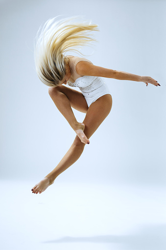 Woman dancer jump in studio on white background