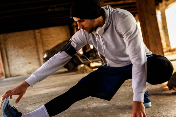 istock Young man stretching his muscles in old warehouse 639002338