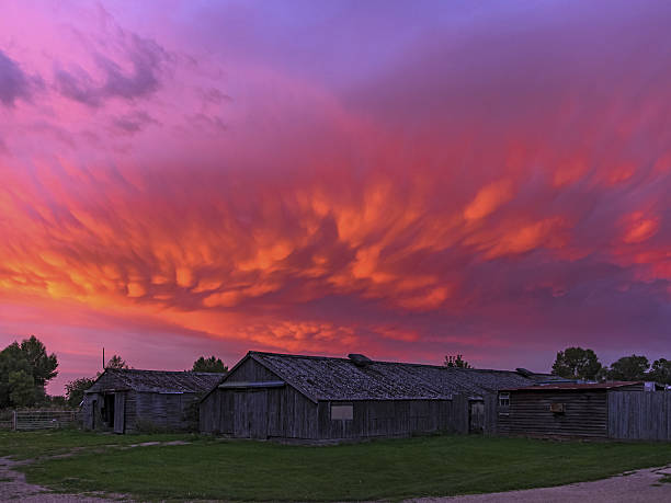 古い農場の建物の夕日に鮮やかなマンマトゥス雲 - baseball sky old sport ストックフォトと画像
