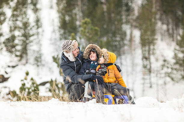 istock Two brothers having winter fun sliding on show 639003572