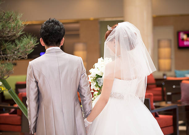 istock Bride and groom walking in hotel lobby 639004596