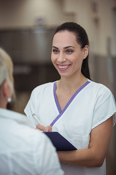 istock Female nurse interacting with patient in corridor 639006838