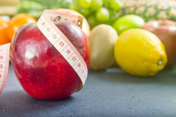 istock Apple and measuring tape over fruity background 639009654