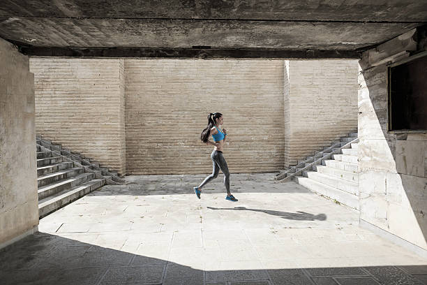 istock Side view of female athlete running in underpass 639010348