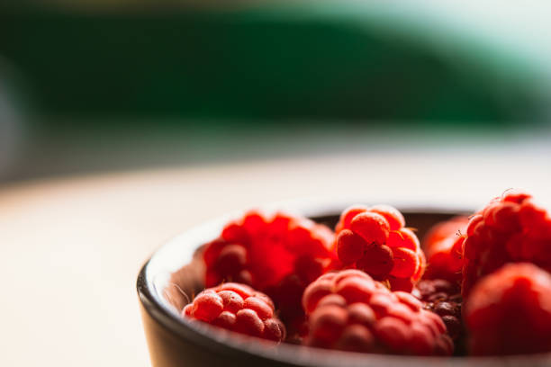 raspberry in a cup on  blurred background of wooden planks