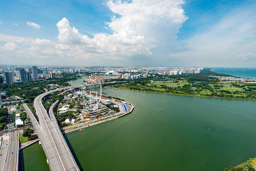 Aerial view of downtown Singapore during a warm day. Singapore River, the Singapore flyer ferris wheel amongst the skyscrapers and highways.