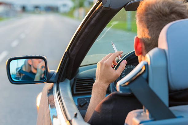 Man with cigarette in car stock photo