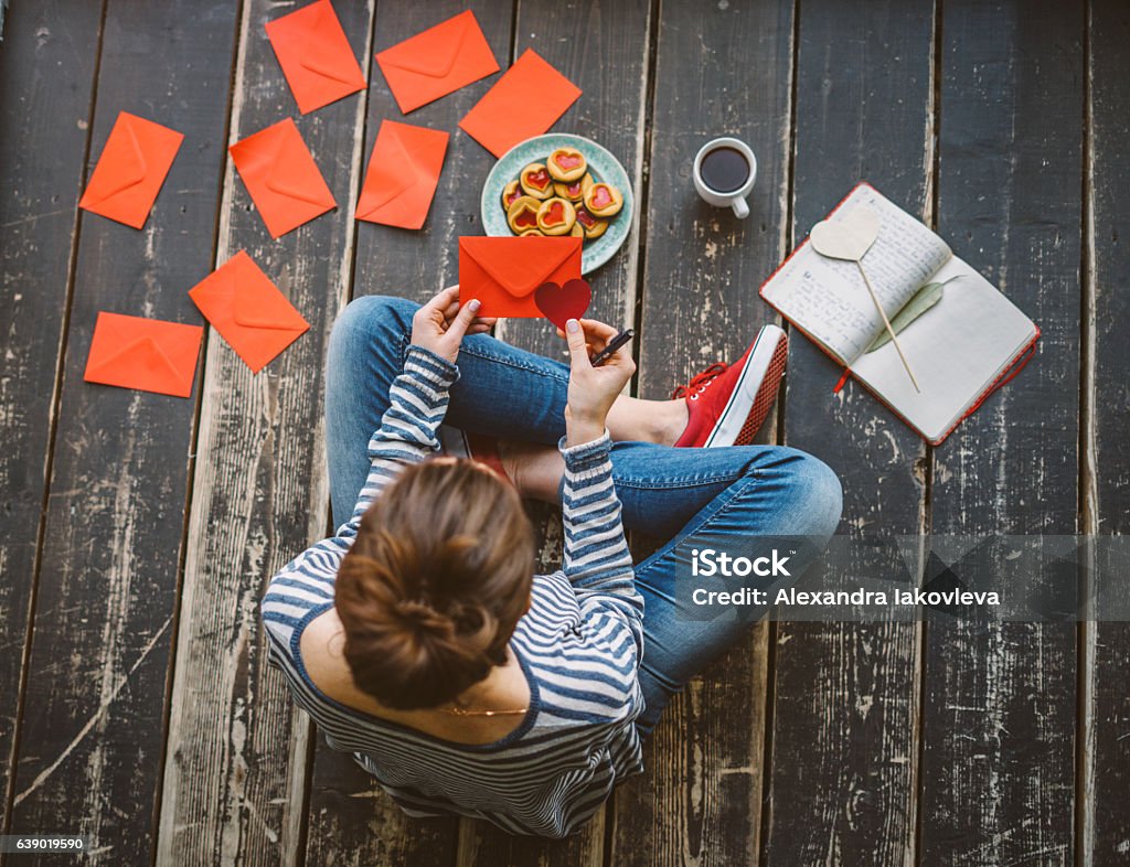 Young woman writing a valentine card - top view Letter - Document Stock Photo