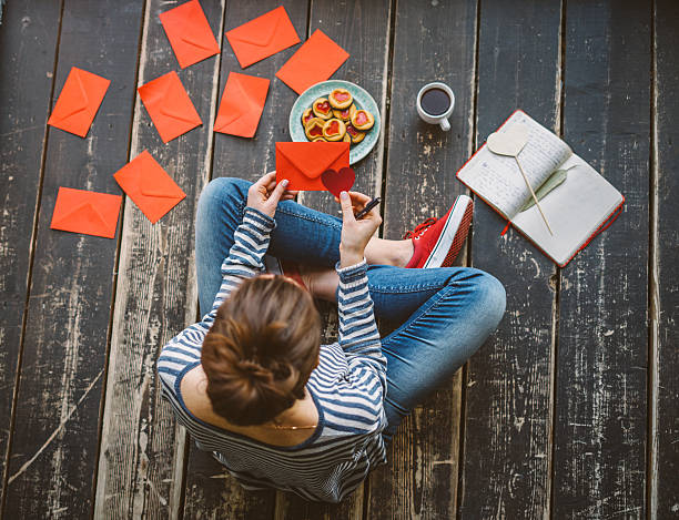 young woman writing a valentine card - top view - writing letter correspondence women imagens e fotografias de stock